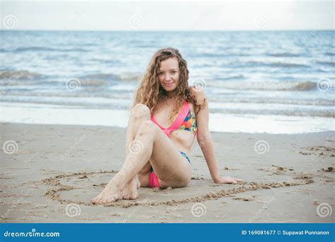 Beautiful Woman On Beach Summer Vacation In Bikini Sitting On Sand In