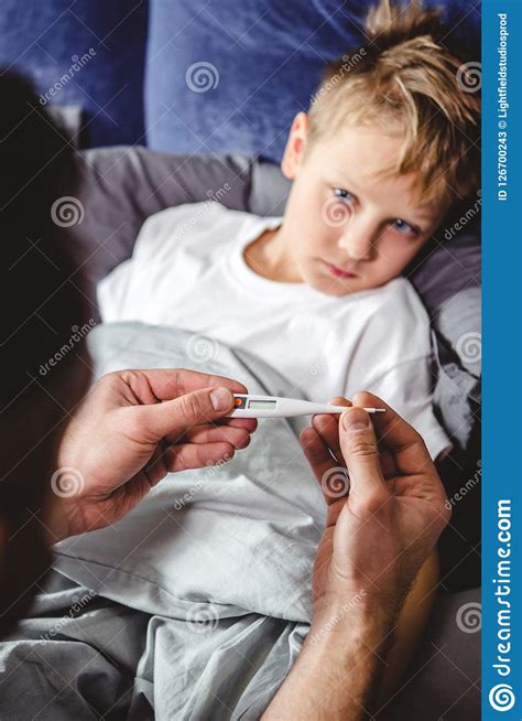 Father Checks The Temperature Of His Son Who Has Stock Image Image Of