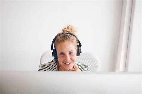 Blonde Happy Woman In An Office Working Behind A Desk Using A Computer