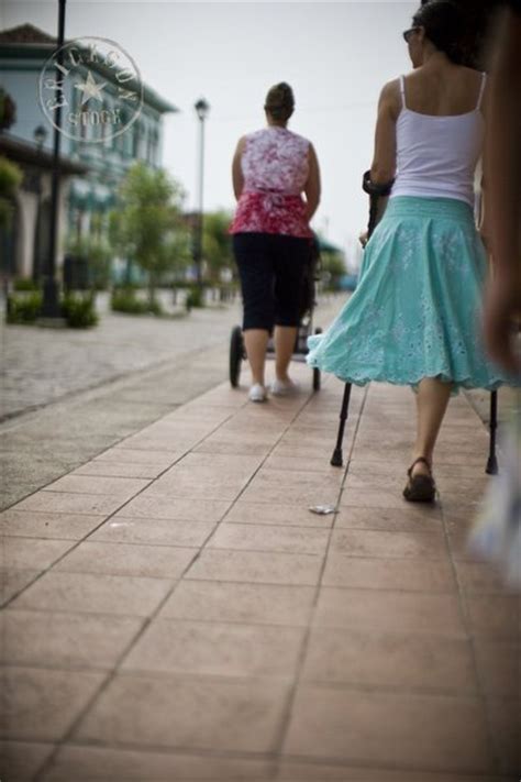 Woman With Pushchair And Woman With One Leg Walking Along