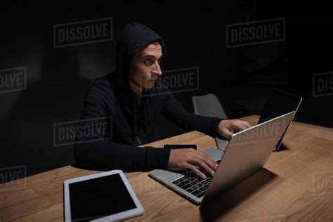 Hacker In Black Hoodie Using Laptops In Dark Room Cyber Security