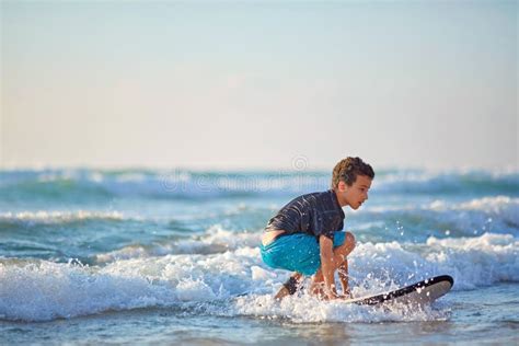 Skilled Teenager Riding Surfboard And Balancing Along Wavy Sea At