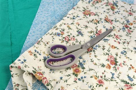 To prepare the fabric, cut the fabric in half and fold one piece in half the long way, then fold in half again, quartering the fabric. Scrap fabric DIY dog toy | The Craft Train