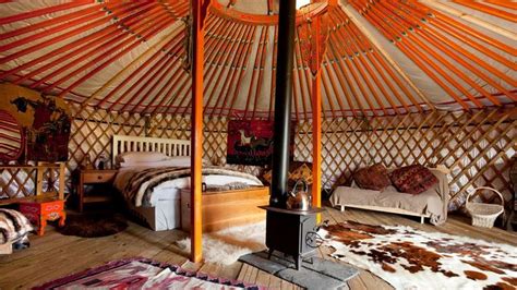 The Inside Of A Yurt With Several Beds And Rugs