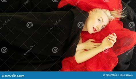 Sensual Seductive Smiling Portrait Of A Young Nude Woman Model Lying Naked In Bed In Black
