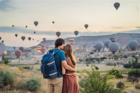Tourists Couple Man And Woman Looking At Hot Air Balloons In Cappadocia