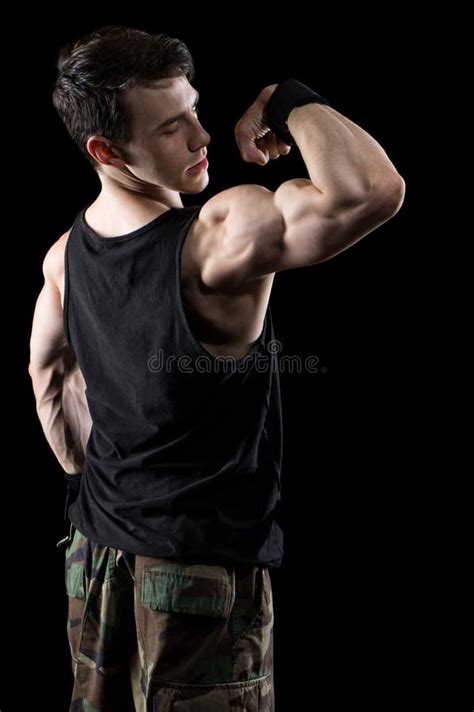 Athletic Man Flexing Muscles In Studio On Dark Background With Smoke