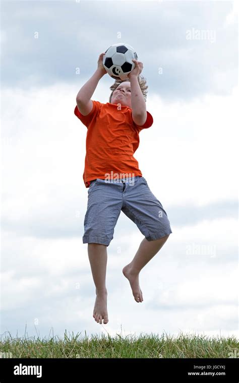 Young Boy Jumping To Catch A Ball Stock Photo Alamy