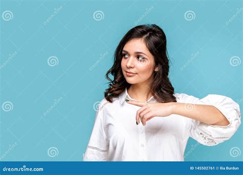 Pretty Brunette Girl Pointing Something By Finger Isolated Over The Blue Background Stock Image