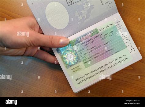 Eastern European Woman Passing Over A Passport With A German Visa On