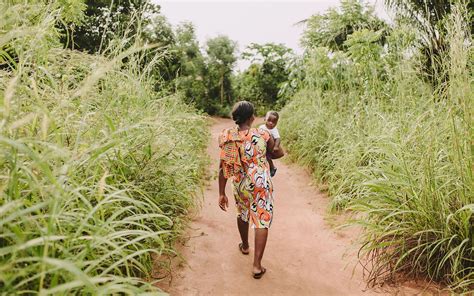 A Mother Walks Through A Jungle Holding Her Baby Mom And Baby Photos