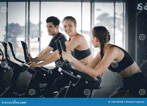 Group Of People Biking In The Gym Exercising Legs Doing Cardio Workout Cycling Bikes Stock
