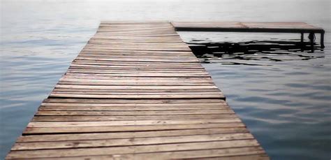 Wooden Dock Extending Out Into The Water On A Lake Bas Associates