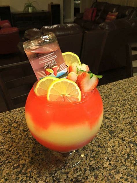 A Drink In A Glass With Lemons And Strawberries On The Rim Sitting On