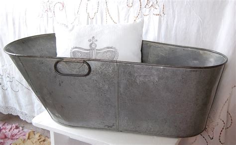 The tubs sit on tall folding metal stands, some of which have been painted. vintage metal baby bathtub
