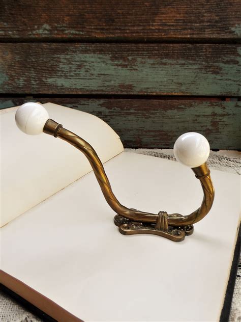 Create an art feature out of a coat rack, with this line of alternating black blocks. Vintage Double Wall Hook Brass and Porcelain Balls Coat ...