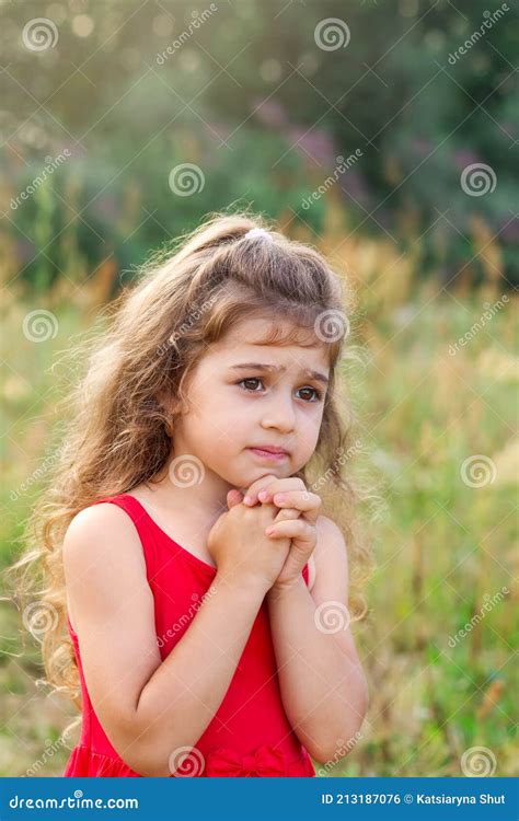 Portrait Of Cute Little Girl Praying In The Park Child Keeping Her