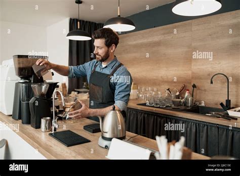 Barista grinds coffee beans before making coffee Stock Photo - Alamy