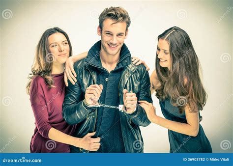 Modern Threesome Love Two Women With Handcuffed Man Stock Photo