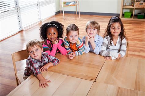 Preschoolers Sitting At Table In Classroom Stock Photo Download Image