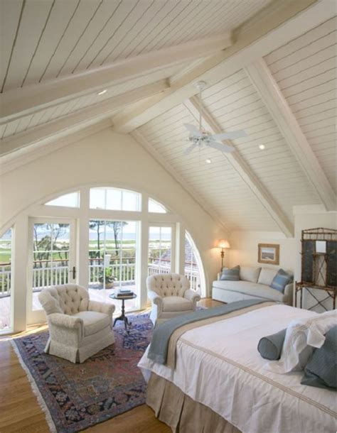 Master Bedroom With Lofty Beamed Ceilings And Arched Window Wall With