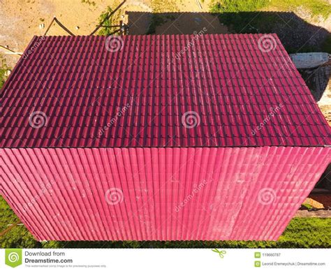 A House With A Red Roof Made Of Corrugated Metal Sheets Roof From