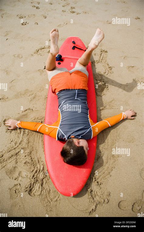 Nine Year Old Boy Lying On Surfboard Stock Photo Alamy