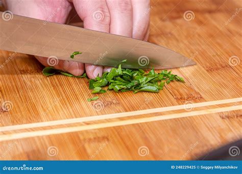Cutting Green Parsley On A Cutting Board With A Knife For Cooking