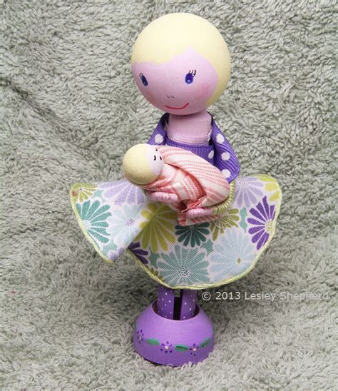 A Clothespin Doll Holds A Baby Doll Made From Beads Wood Peg Dolls