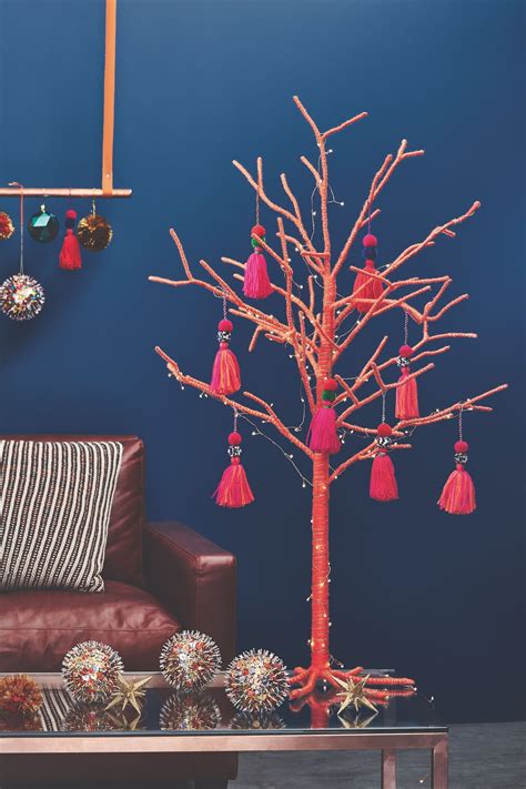 a living room with a couch, table and tree decorated in red tassels
