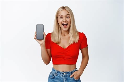 Free Photo Excited Blond Girl Showing Mobile Phone Screen App