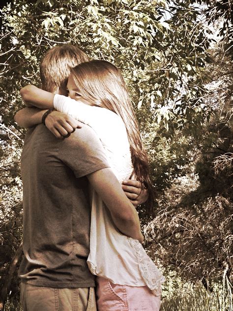 Girl Smiles And Looks Off Into The Distance While The Guy Is Hugging