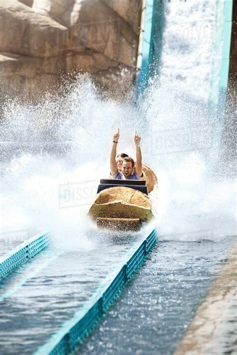 Enthusiastic Young Man Riding Water Log Amusement Park Ride Stock