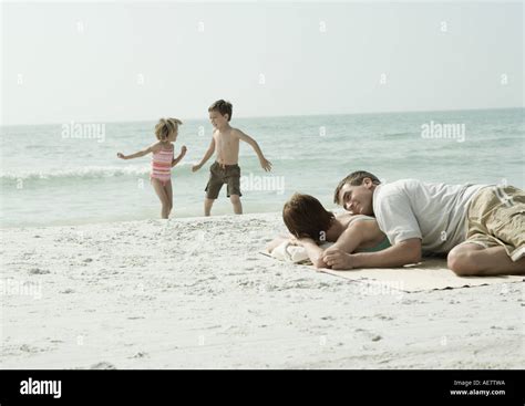Eltern Am Strand Liegen Während Die Kinder Spielen Im Hintergrund