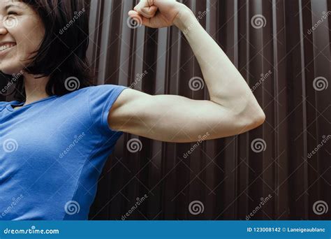 Smiling Woman Flexing Her Biceps Outdoors Stock Photo Image Of Focus