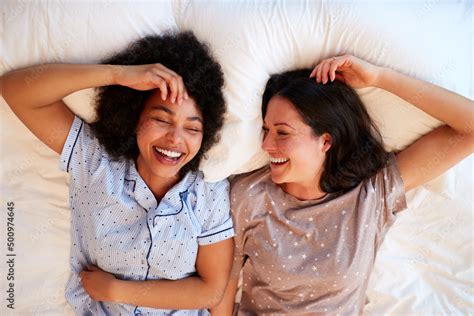 Overhead Portrait Of Loving Same Sex Female Couple Wearing Pyjamas