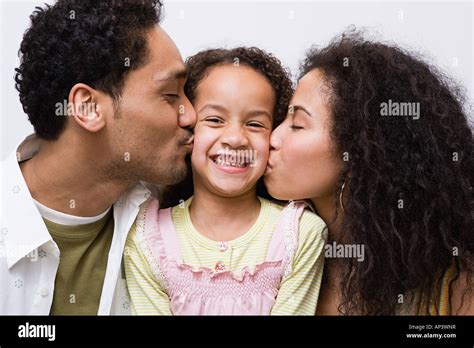 El Padre Y La Madre Besando A Su Hija En La Mejilla Fotografía De Stock