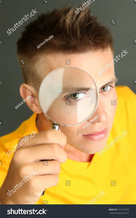 Young Man Looking Through Magnifying Glass Stock Photo 151215275