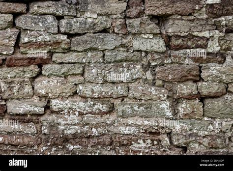 The Surface Of An Old Stone Wall Masonry Of Uneven Wild Hewn Stones