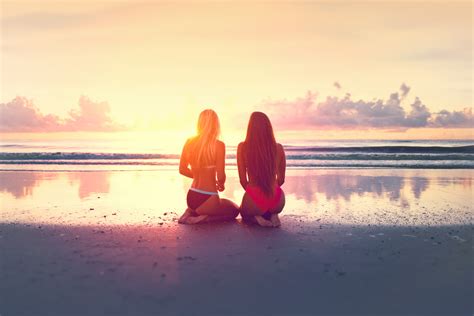 Free Photo Two Young Women Watching The Sunset Over The Ocean