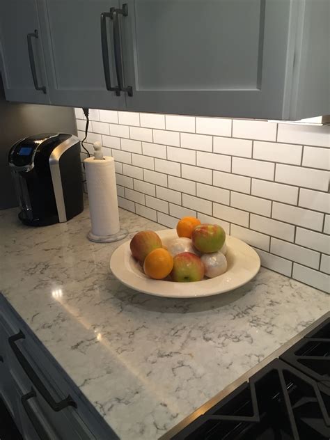 Open concept small but updated kitchen. 3cm Viatera quartz Rococo showing subway tile backsplash ...