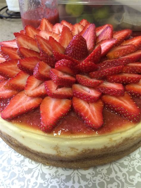 new york cheesecake topped with fresh strawberry sauce and garnished with fresh strawberry