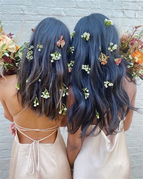 Two Women With Flowers In Their Hair Are Facing Each Other And One Has