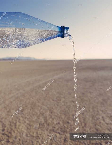 Water Pouring From Bottle In Landscape Of Black Rock Desert In Nevada