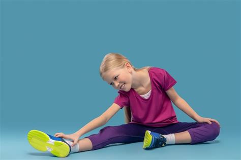 Premium Photo Achieve Result Blonde Tense Elementary School Age Girl Sitting On Floor Bending