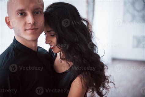 Portrait Of Happy Couple Indoors Bald Guy And Brunette Woman Stands In