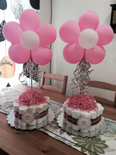 Have your cake filled with hand embroidered baby items. Diaper cake with flower balloons as table centerpieces ...