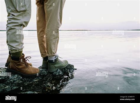 Close Up Of Unrecognizable Couple In Hiking Boots Standing On Rock And