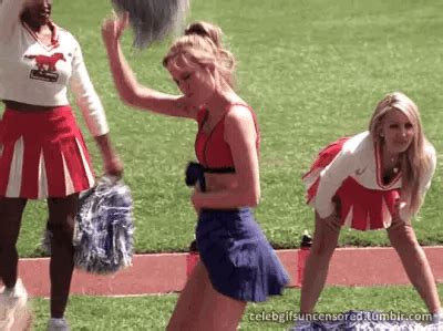 Two Cheerleaders In Red And White Outfits On The Sidelines