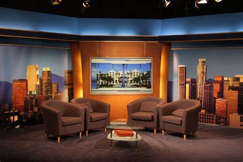 Two Chairs And A Couch In Front Of A Television Set With Cityscape On